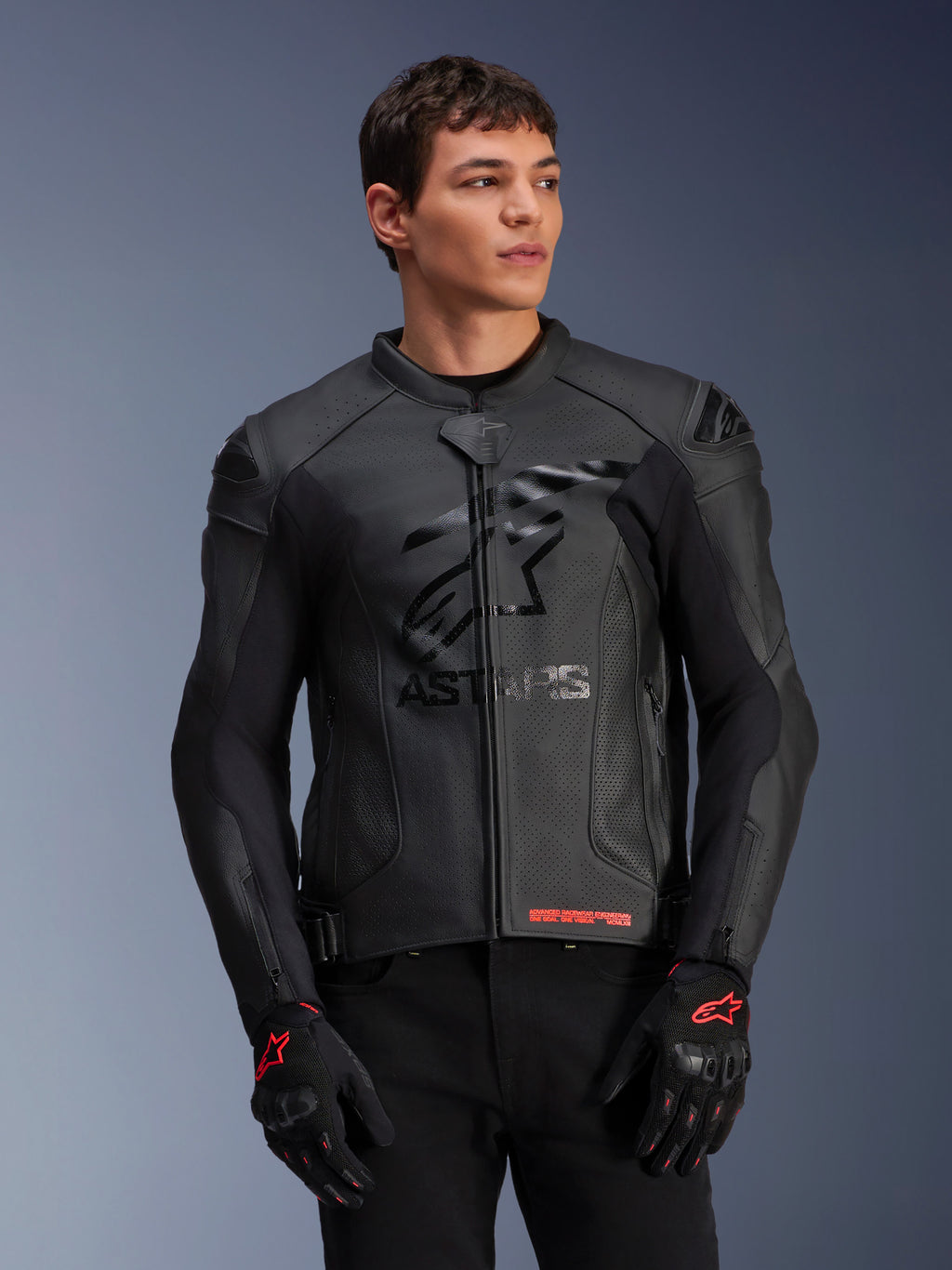 Alpinestars GP Plus R V4 Airflow Leather Jacket, czarna, wyścigowa kurtka motocyklowa o perforowanej skórzanej konstrukcji, z wyraźnym logo ASTARS na piersi i ochroną ramion DFS, noszona z czarno-czerwonymi rękawicami
