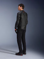 Alpinestars GP Plus R V4 Airflow Leather Jacket, męska sportowa kurtka motocyklowa, czarna, widok na modelu z tyłu pod kątem trzech czwartych, posiada perforowane panele skórzane, czerwone logo na plecach i zintegrowaną ochronę ramion, noszona z czarnymi spodniami i butami motocyklowymi