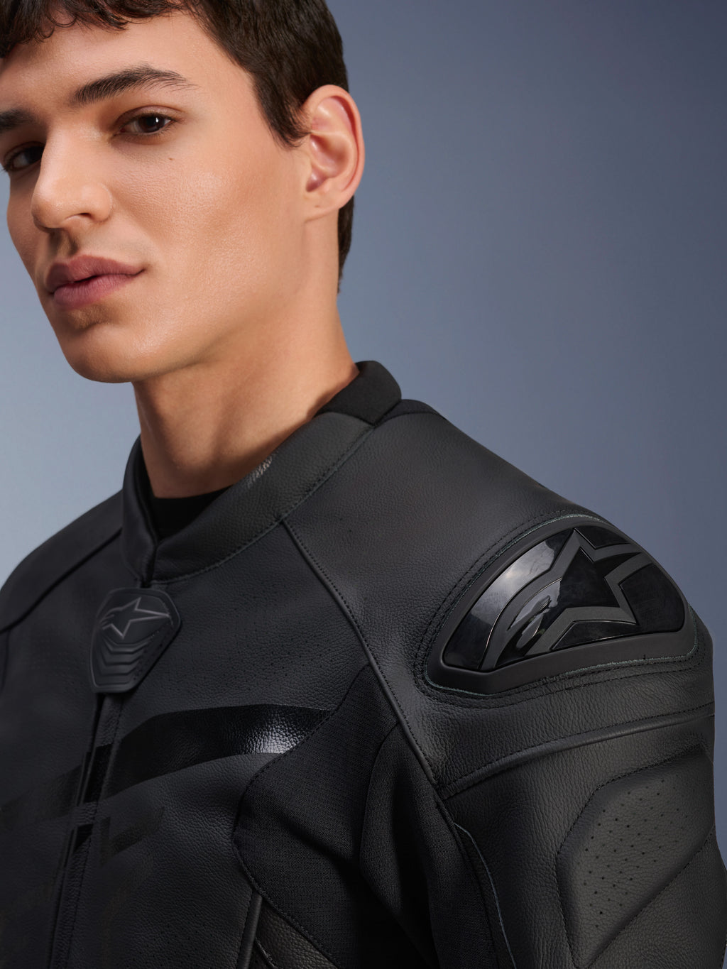 Alpinestars GP Plus R V4 Airflow Leather Jacket, czarna, zbliżenie na modela przedstawiające ochraniacz ramion DFS o podwójnej gęstości i perforowaną skórę, profesjonalna sportowa odzież motocyklowa