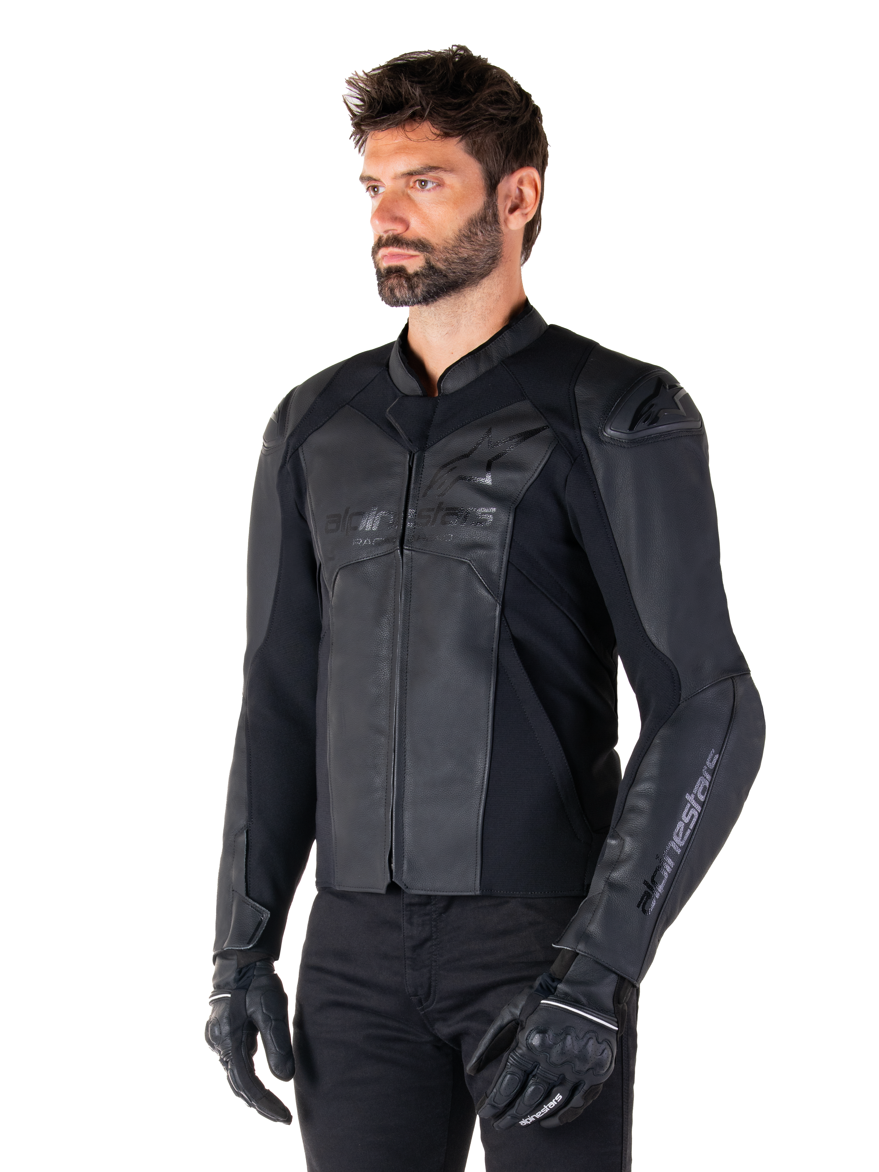 Skórzana kurtka Alpinestars Faster V3, sportowa kurtka motocyklowa, czarna, noszona przez modela w czarnych spodniach i rękawicach, konstrukcja ze skóry premium z elastycznymi panelami i ochraniaczami ramion DFS GP Lite, smukła i nowoczesna sportowa sylwetka