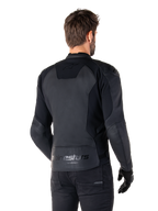 Alpinestars Faster V3 Leather Jacket, Black Black, widok z tyłu modelu w sportowej kurtce motocyklowej, z logo „alpinestars” i napisem „RACING AHEAD” na dole pleców, skóra premium z matowymi panelami, nowoczesna sportowa sylwetka do jazdy motocyklem