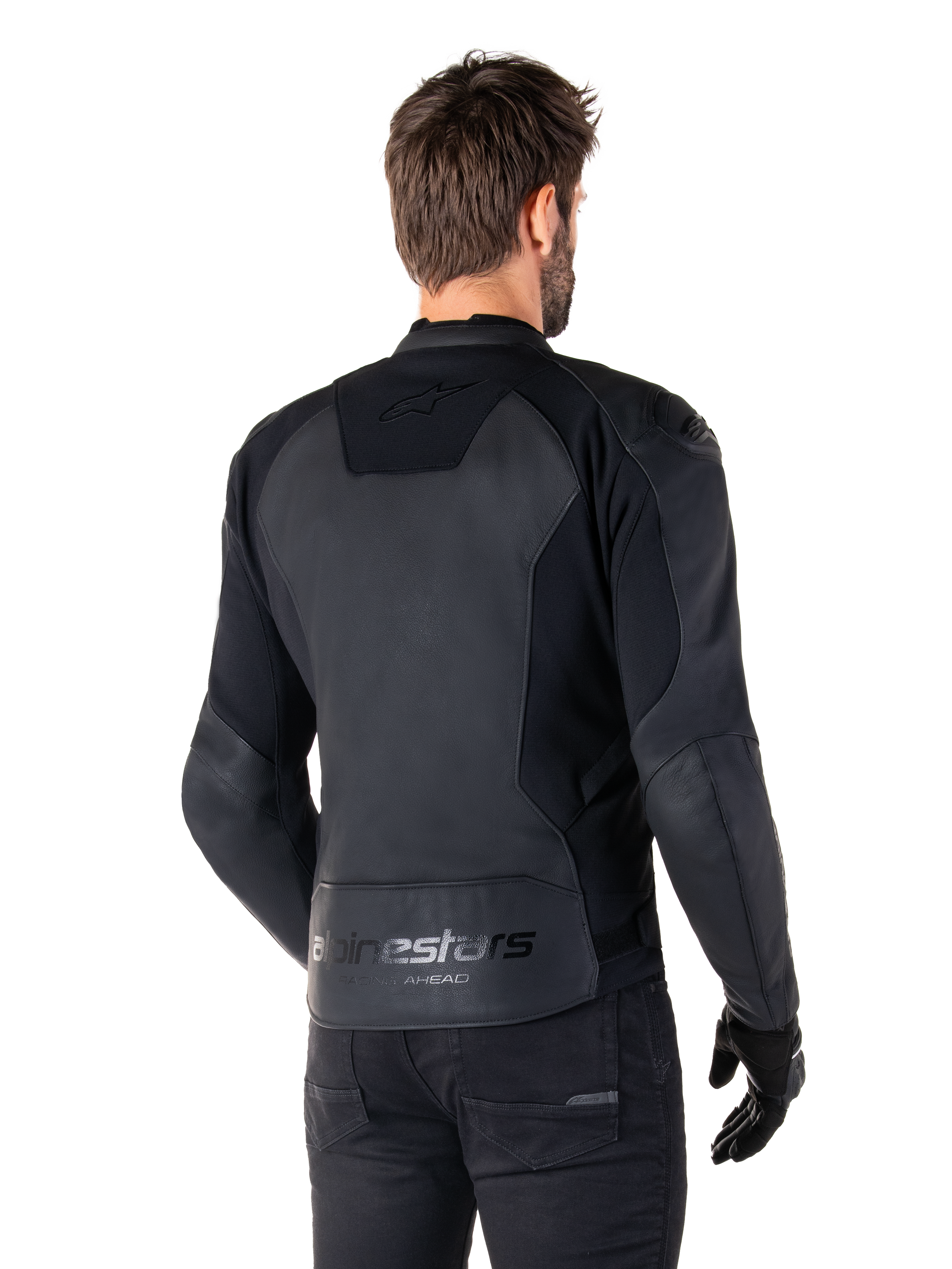 Alpinestars Faster V3 Leather Jacket, Black Black, widok z tyłu modelu w sportowej kurtce motocyklowej, z logo „alpinestars” i napisem „RACING AHEAD” na dole pleców, skóra premium z matowymi panelami, nowoczesna sportowa sylwetka do jazdy motocyklem
