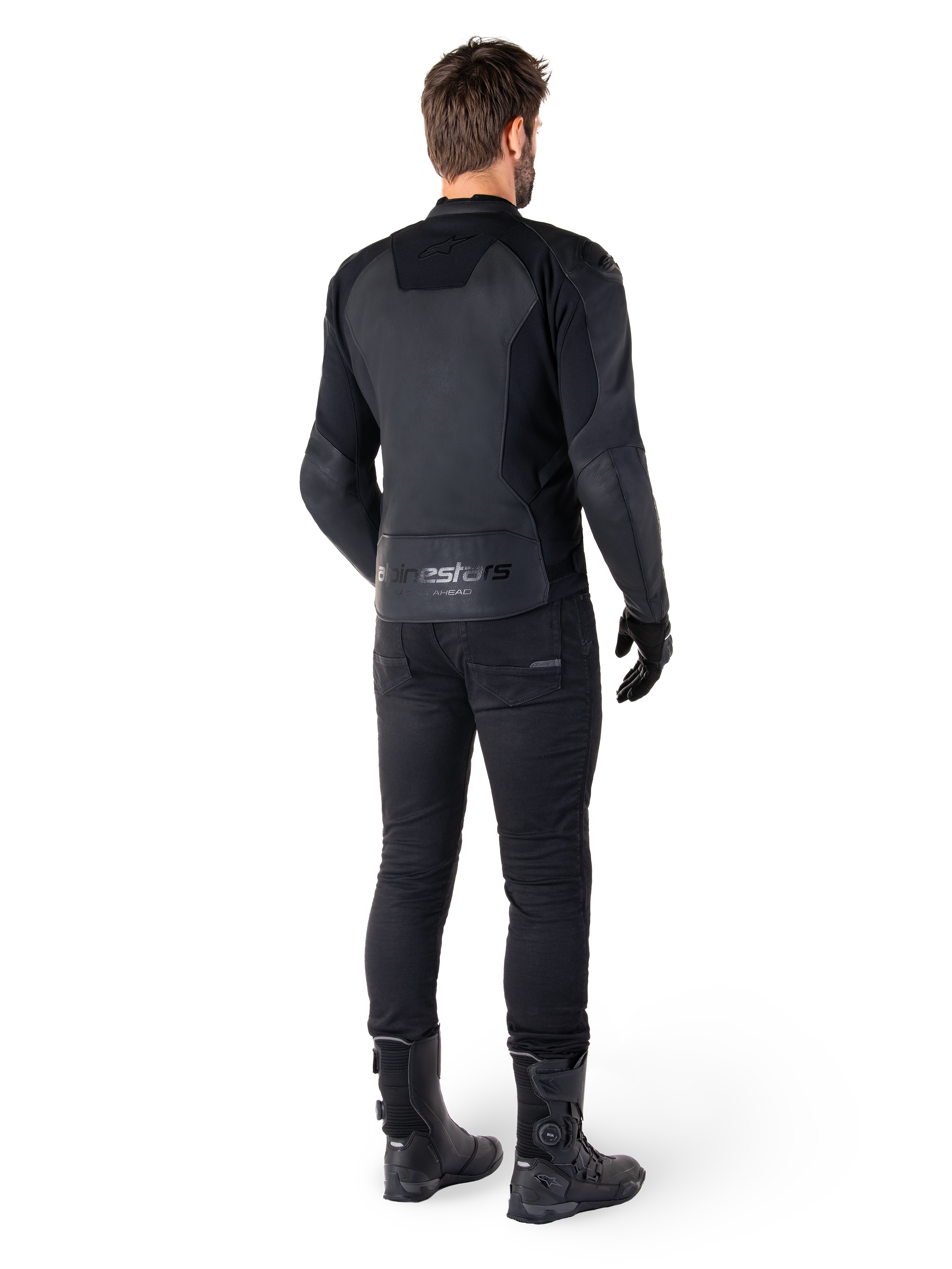 Skórzana kurtka Alpinestars Faster V3, Black Black, widok z tyłu na motocykliście, z panelami ze skóry premium i wytłaczanym logo Alpinestars, zestawiona z czarnymi spodniami i butami motocyklowymi dla pełnego sportowego wyglądu.