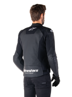 Alpinestars Faster V3 Airflow Leather Jacket, Black and White, rear view on a model, featuring perforated leather back for ventilation, white Astars logos on the upper back and lower waist with 'Racing Ahead' text, sporty design with stretch panels for motorcycling.