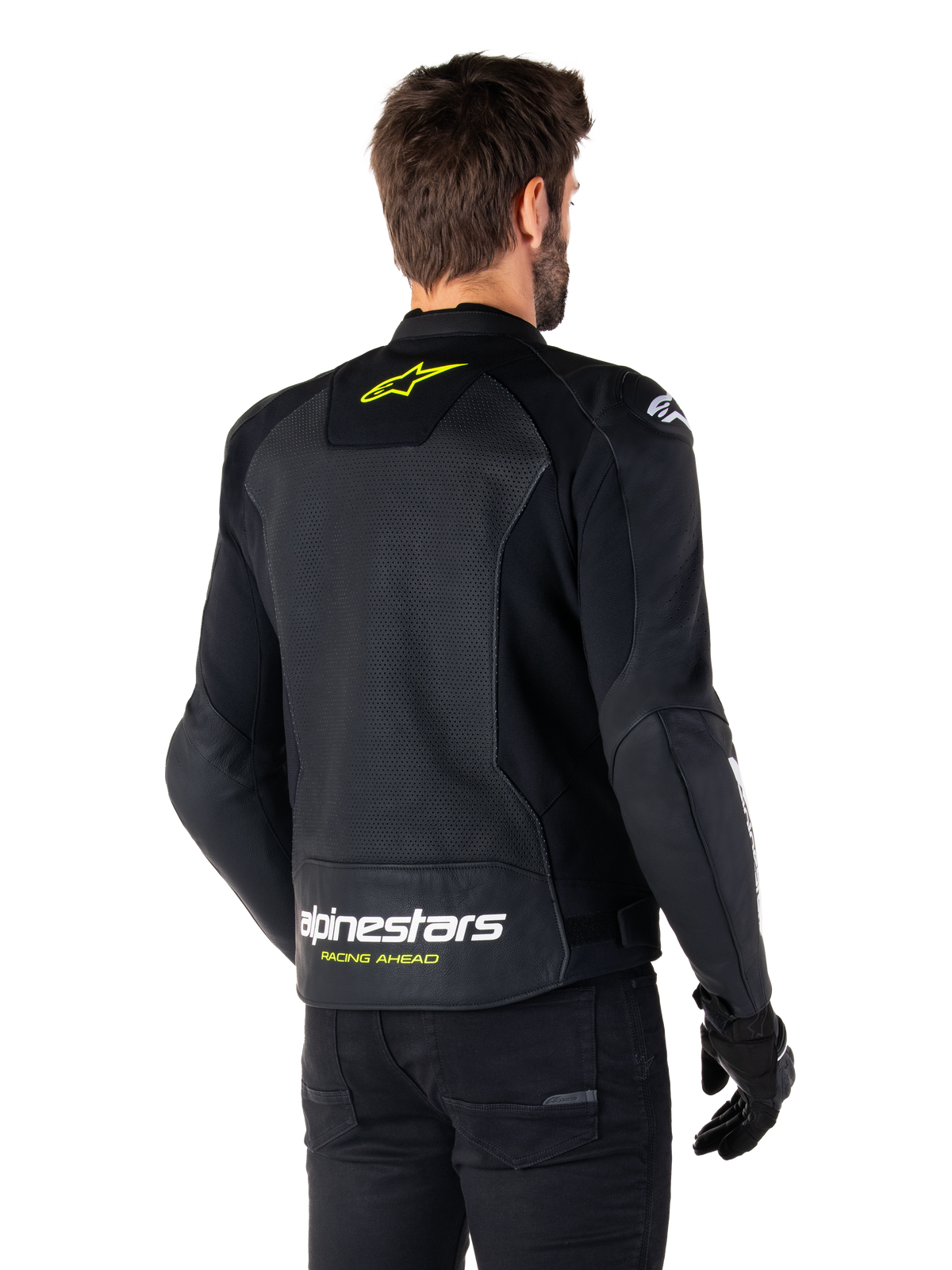 Kurtka skórzana Alpinestars Faster V3 Airflow, czarna z białymi i neonowożółtymi elementami, widok z tyłu, duży perforowany panel na plecach dla wentylacji, żółte logo gwiazdy na kołnierzu, biały napis Alpinestars i żółty tekst „Racing Ahead” na dolnej krawędzi, sportowa odzież motocyklowa
