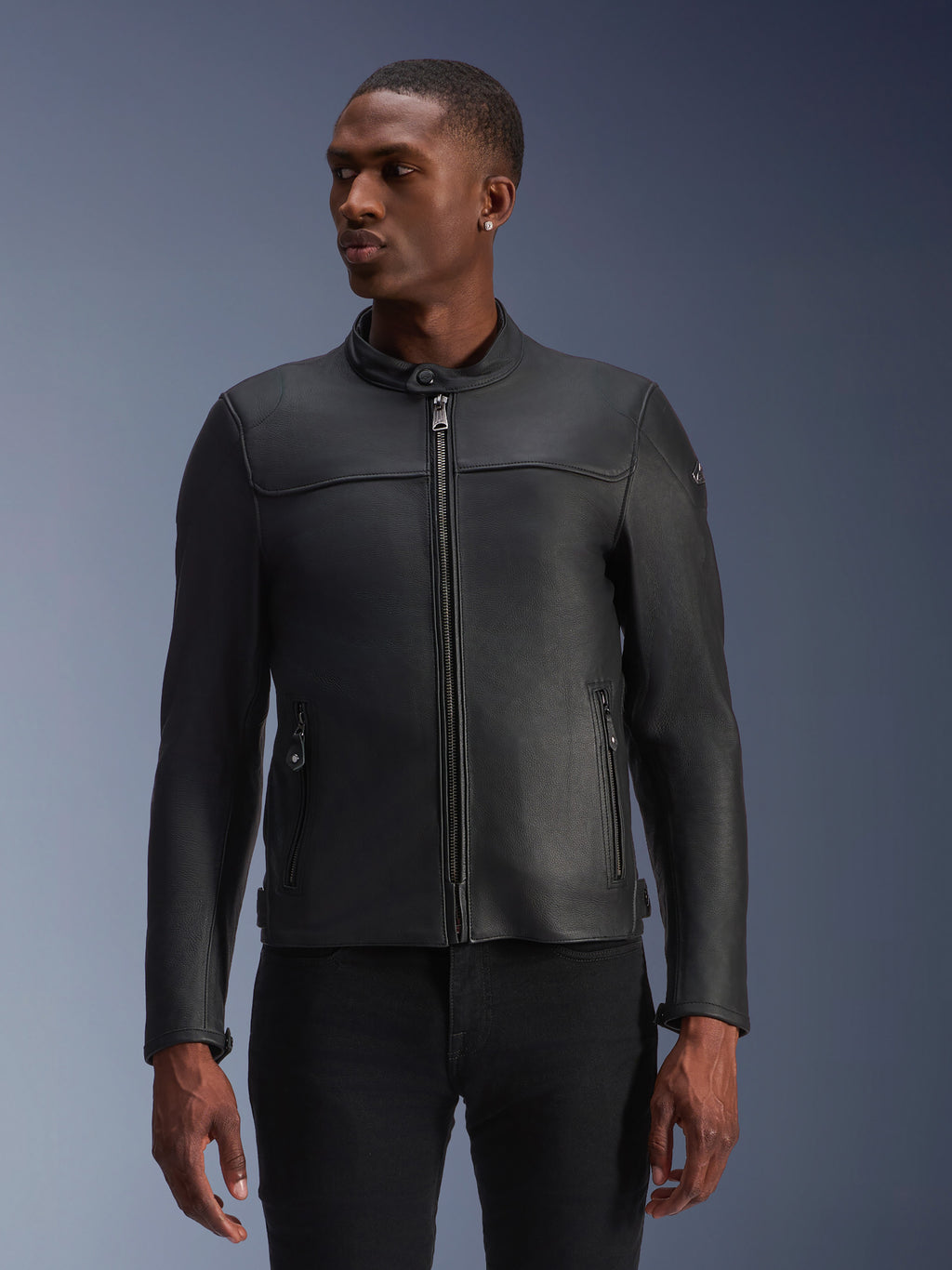 Alpinestars Blacktrack, skórzana kurtka motocyklowa, czarna, prezentowana na modelu, z metalowym przednim zamkiem błyskawicznym, wysokim kołnierzem i kieszeniami na zamek, gładka konstrukcja ze skóry premium o nowoczesnym, minimalistycznym wyglądzie