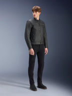 Alpinestars Dyno Leather Jacket in Black, premium bovine leather motorcycle jacket, worn by male model with black slim-fit pants and black boots, heritage-inspired minimalist design for urban contemporary riding, studio setting.