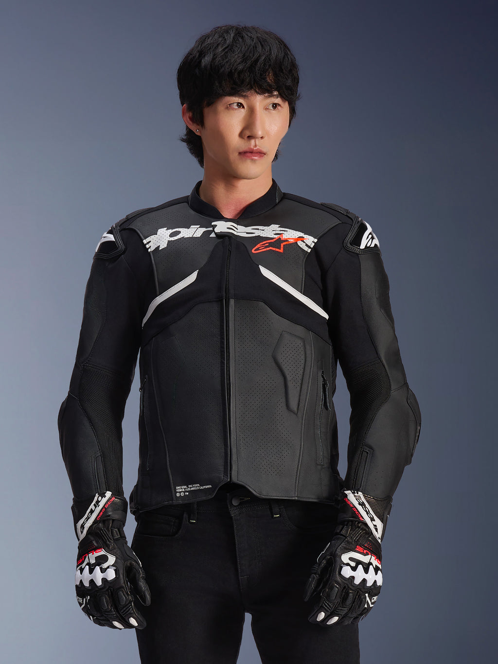 Alpinestars Atem V5 Leather Jacket, wyścigowa kurtka motocyklowa, czarna z białymi i czerwonymi akcentami, konstrukcja ze skóry premium z ochronnym pancerzem, noszona z pasującymi rękawicami wyścigowymi