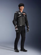 Skórzana kurtka Alpinestars Atem V5, motocyklowa kurtka wyścigowa, czarno-biała, noszona z czarnymi spodniami i dopasowanymi rękawicami, z białym logo Alpinestars na klatce piersiowej i ochronnymi protektorami ramion