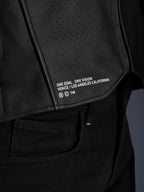 Skórzana kurtka Alpinestars Atem V5, czarna, zbliżenie na dolny tylny panel z napisem „ONE GOAL. ONE VISION. VENICE / LOS ANGELES CALIFORNIA”, widoczna tekstura perforowanej skóry
