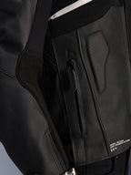 Skórzana kurtka Alpinestars Atem V5, czarna, zbliżenie na detal boku tułowia z kieszenią na zamek, perforowany panel skórzany, biały odblaskowy akcent i napis „One Goal. One Vision.”, wysokowydajna odzież motocyklowa