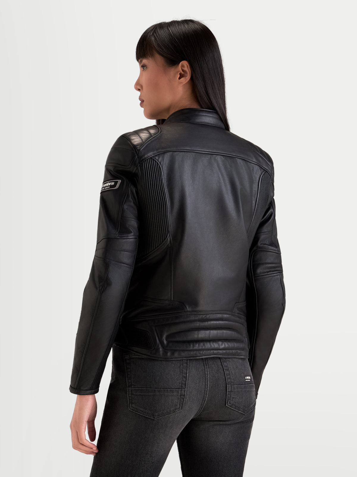 Alpinestars Revea Kobiety kurtka skórzana motocyklowa miejska, czarna, widok z tyłu prezentujący konstrukcję z wysokiej jakości skóry licowej oraz ochraniacze ramion noszone przez modelkę
