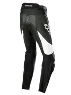 Alpinestars Stella Missile V3 Leather Pants, damskie motocyklowe spodnie wyścigowe, czarne z białymi akcentami, widok z tyłu pod kątem trzech czwartych pokazujący elastyczne panele harmonijkowe w dolnej części pleców, logo Alpinestars na udzie oraz zintegrowane slidery kolan do jazdy sportowej.