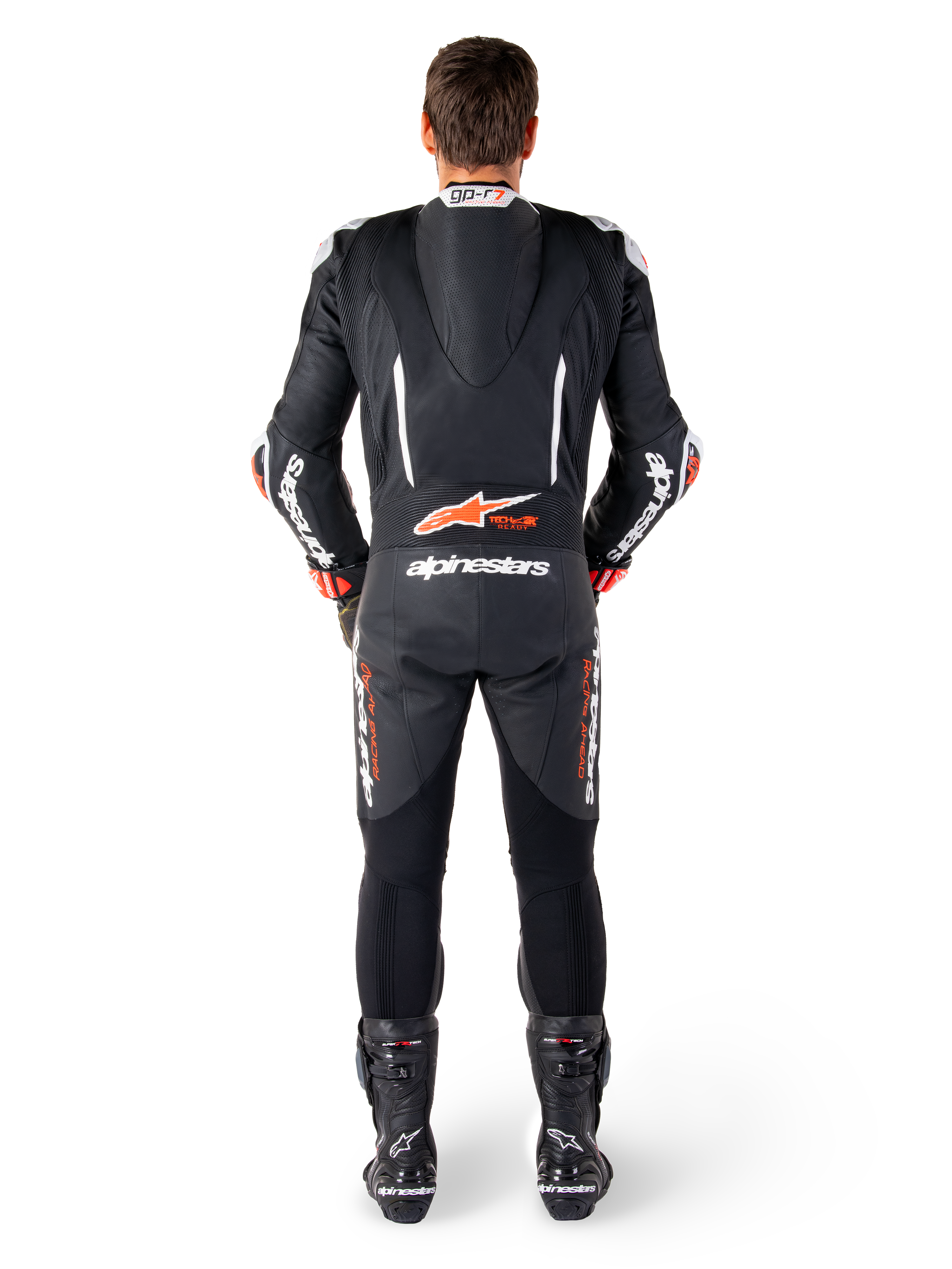 Skórzany kombinezon Alpinestars GP-R7, czarno-biało-czerwony, aerodynamiczny garb i panele harmonijkowe, widok od tyłu.