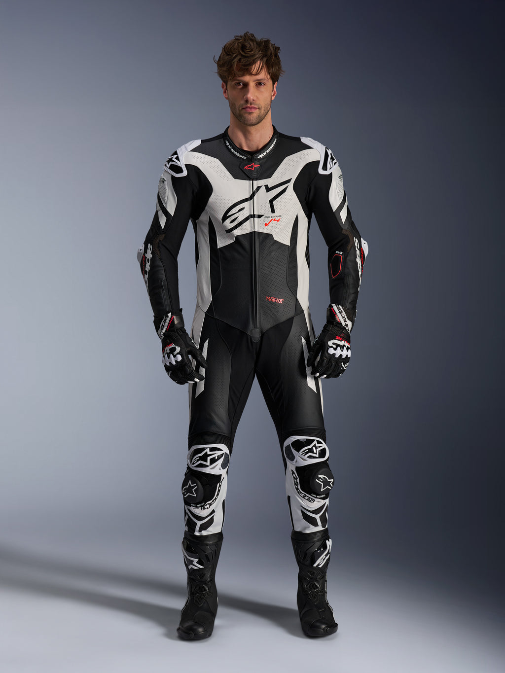 Alpinestars GP Plus V4 Sprint, męski jednoczęściowy skórzany kombinezon wyścigowy, czarno-biały z czerwonymi detalami fluo.