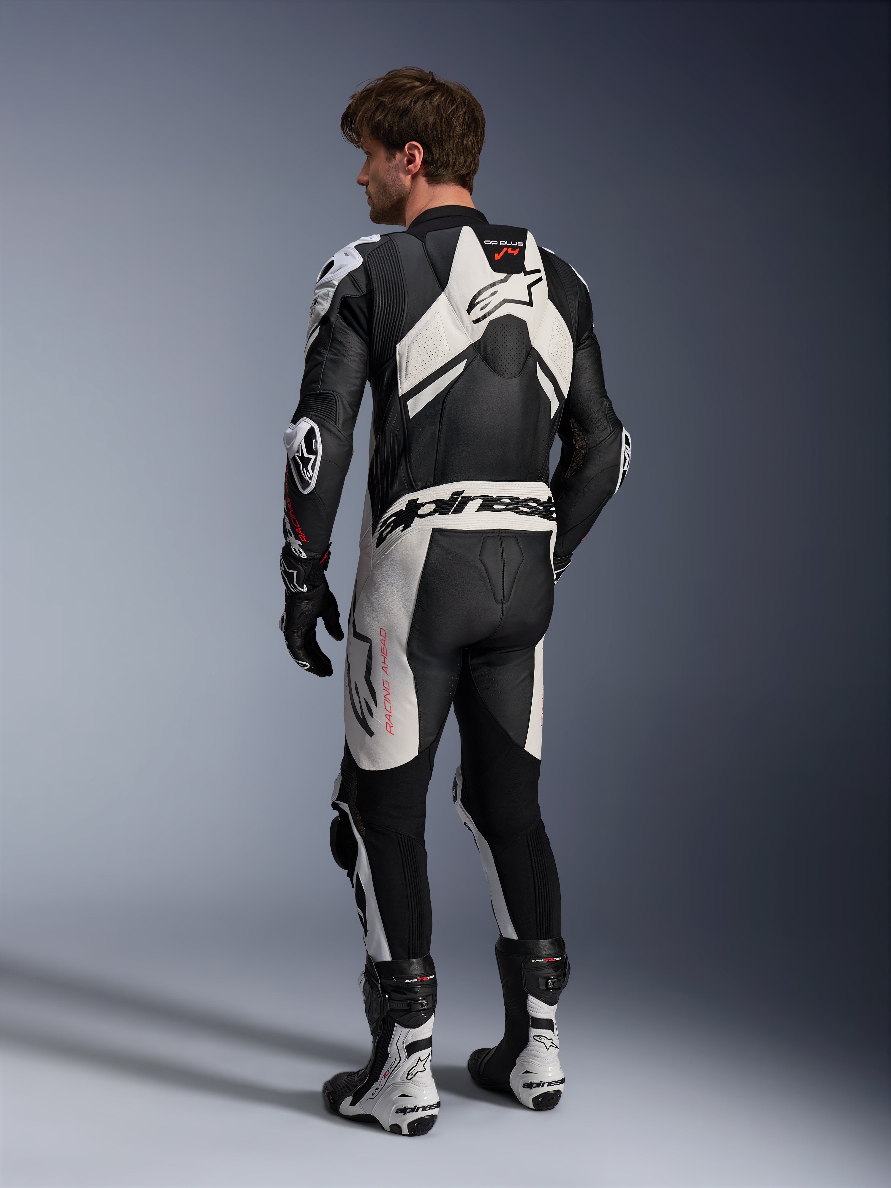 Alpinestars GP Plus V4 Sprint 1PC, męski skórzany kombinezon wyścigowy, czarno-biały, widok z tyłu z garbem aerodynamicznym.