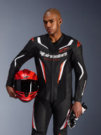 Alpinestars GP Force V2 Leather Suit, jednoczęściowy kombinezon motocyklowy, czarny, biały i czerwony fluo, prezentowany przez modela trzymającego czerwony kask i rękawice, sportowy design z perforowaną skórą i wyraźnym brandingiem