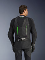 Jednoczęściowy kombinezon skórzany Alpinestars GP Force V2, czarno-zielony, widok z tyłu przedstawiający aerodynamiczny garb, oznaczenie Tech-Air Ready, perforowane strefy skórzane i harmonijkowe panele elastyczne do wyścigów motocyklowych