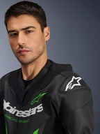 Alpinestars GP Force V2 Leather Suit - 1Piece, czarno-zielony, zbliżenie na modela w motocyklowym kombinezonie wyścigowym, białe i zielone logotypy, perforowane panele skórzane, ochraniacz ramion DFS Lite z białą gwiazdą