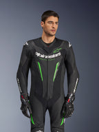 Alpinestars GP Force V2 Leather Suit - 1Piece, czarno-zielony motocyklowy kombinezon wyścigowy prezentowany przez modela, z perforowanymi panelami skórzanymi, wyraźnym białym logo Alpinestars na klatce piersiowej i rękawach oraz zintegrowaną ochroną ramion.