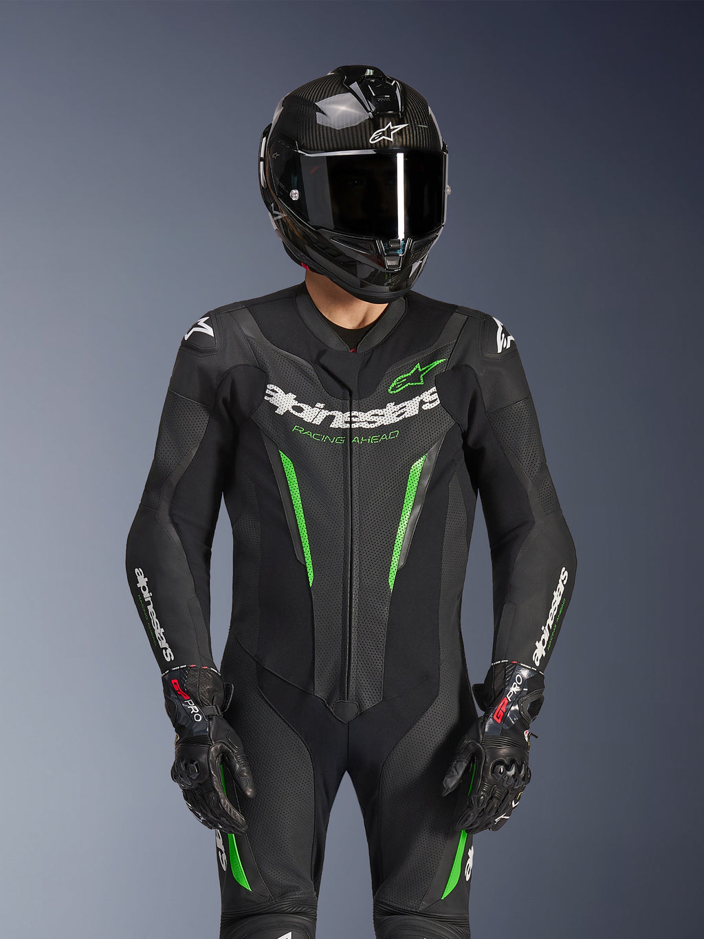 Alpinestars GP Force V2 Leather Suit - 1Piece, czarno-zielony, motocyklowy kombinezon wyścigowy noszony z kaskiem z włókna węglowego i rękawicami GP Pro, z limonkowymi akcentami i brandingiem Alpinestars „Racing Ahead”, zaprojektowany z myślą o osiągach na torze.
