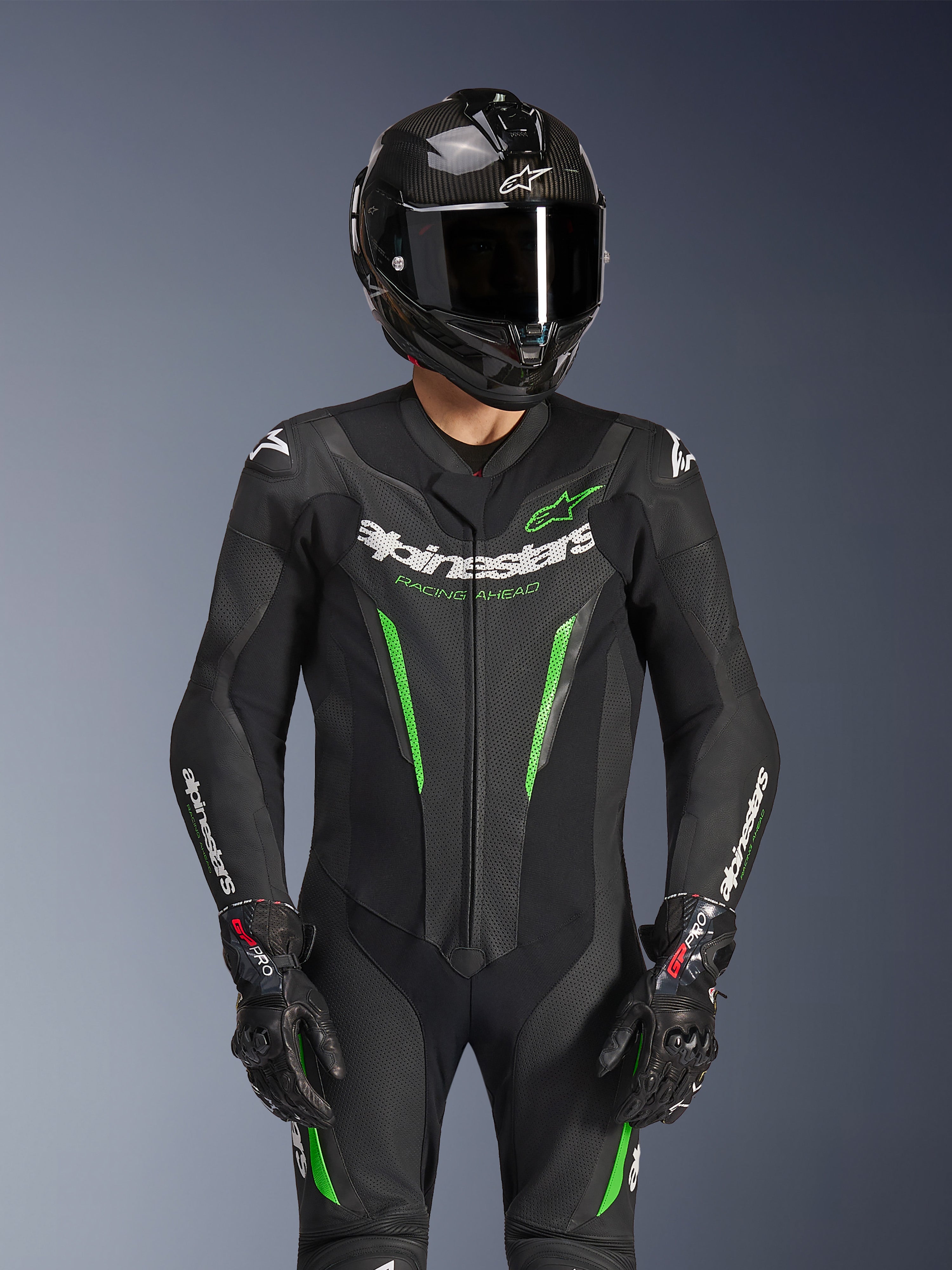 Alpinestars GP Force V2 Leather Suit - 1Piece, czarno-zielony, motocyklowy kombinezon wyścigowy noszony z kaskiem z włókna węglowego i rękawicami GP Pro, z limonkowymi akcentami i brandingiem Alpinestars „Racing Ahead”, zaprojektowany z myślą o osiągach na torze.
