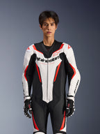 Alpinestars GP Force V2 Leather Suit - 1Piece, biało-czarno-czerwony fluo, prezentowany przez męskiego modela, perforowane panele skórzane, wyraźne logo Alpinestars na klatce piersiowej, czarno-białe rękawice wyścigowe, zaprojektowany do jazdy torowej i sportowej