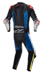 Alpinestars GP Tech V4 Leather Suit, jednoczęściowy kombinezon skórzany, czarny z niebieskimi panelami i czerwonymi akcentami fluo, widok z tyłu ukazujący garb aerodynamiczny oraz branding Tech-Air Ready, białe rękawy z czarną grafiką i żółtymi detalami fluo na nogawkach, profesjonalny sprzęt wyścigowy.