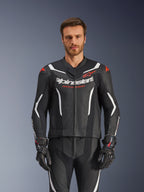 Alpinestars GP Force V2 Leather Suit- 2Piece, czarno-biało-czerwony fluo, widok z przodu na modela ubranego w perforowany kombinezon skórzany i pasujące czarne rękawice, z białymi kanciastymi akcentami i logo Alpinestars na klatce piersiowej