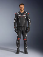 Alpinestars GP Force V2 2-Piece Leather Suit, dwuczęściowy skórzany kombinezon motocyklowy, czarny, biały i czerwony fluo, prezentowany przez modela z pasującymi czarnymi rękawicami i butami, wyposażony w perforowane panele skórzane, białe i czerwone akcenty fluo oraz aerodynamiczny design do jazdy torowej i sportowej