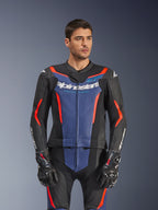 Męski model w dwuczęściowym skórzanym kombinezonie Alpinestars GP Force V2, kolor Black Blue Red Fluo, z wyraźnym niebieskim panelem na klatce piersiowej i czerwonymi akcentami, zestawiony z rękawicami GP Pro, profesjonalna skórzana odzież motocyklowa o perforowanej teksturze