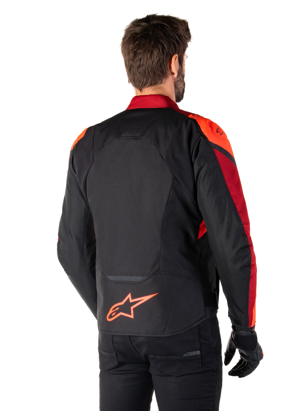 Widok z tyłu na mężczyznę ubranego w kurtkę Alpinestars T-Jaws V4 Waterproof w kolorze Black Red Fluo Dark Red, z jaskrawoczerwonymi akcentami na ramionach i rękawach, neonowym czerwonym logo Alpinestars na dole pleców, w zestawieniu z czarnymi spodniami i rękawicami.