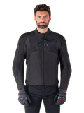 Kurtka motocyklowa Alpinestars T-Jaws V4 Waterproof, czarna sportowa kurtka motocyklowa, prezentowana na mężczyźnie w czarnych rękawicach z czerwonymi akcentami, wzmocnione barki i ramiona, elegancki design z subtelnym logo na klatce piersiowej, tekstylna odzież motocyklowa na każdą pogodę