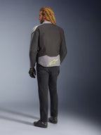 Alpinestars T-Jaws V4 Waterproof Jacket, widok z tyłu, kolorystyka Black Ice Gray i Dark Gray, z neonowożółtym logo Alpinestars w dolnej części pleców, noszona z czarnymi spodniami i rękawicami motocyklowymi, sportowa odzież motocyklowa