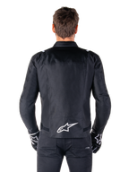 Alpinestars T-SPS V2 Waterproof Jacket, czarno-biała, widok z tyłu z białym logo Alpinestars na dole pleców, zestaw z czarnymi spodniami i rękawicami, tekstylna kurtka motocyklowa o sportowym kroju
