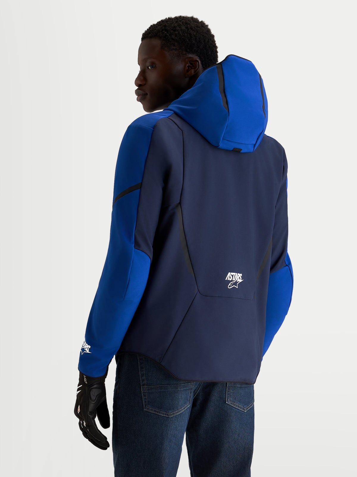 Alpinestars Aeroshell WP, męska kurtka motocyklowa softshell, granatowa i niebieska, z kapturem i rękawicami motocyklowymi, widok z tyłu na modela