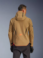 Wodoodporna kurtka Alpinestars Aeroshell, Dark Khaki i Orange Fluo, widok z tyłu prezentujący fason bluzy z kapturem z pomarańczowym wykończeniem kaptura i dolnej krawędzi, pomarańczowe logo w dolnej części pleców, zestawiona z czarnymi rękawicami, sportowa odzież motocyklowa typu softshell crossover.