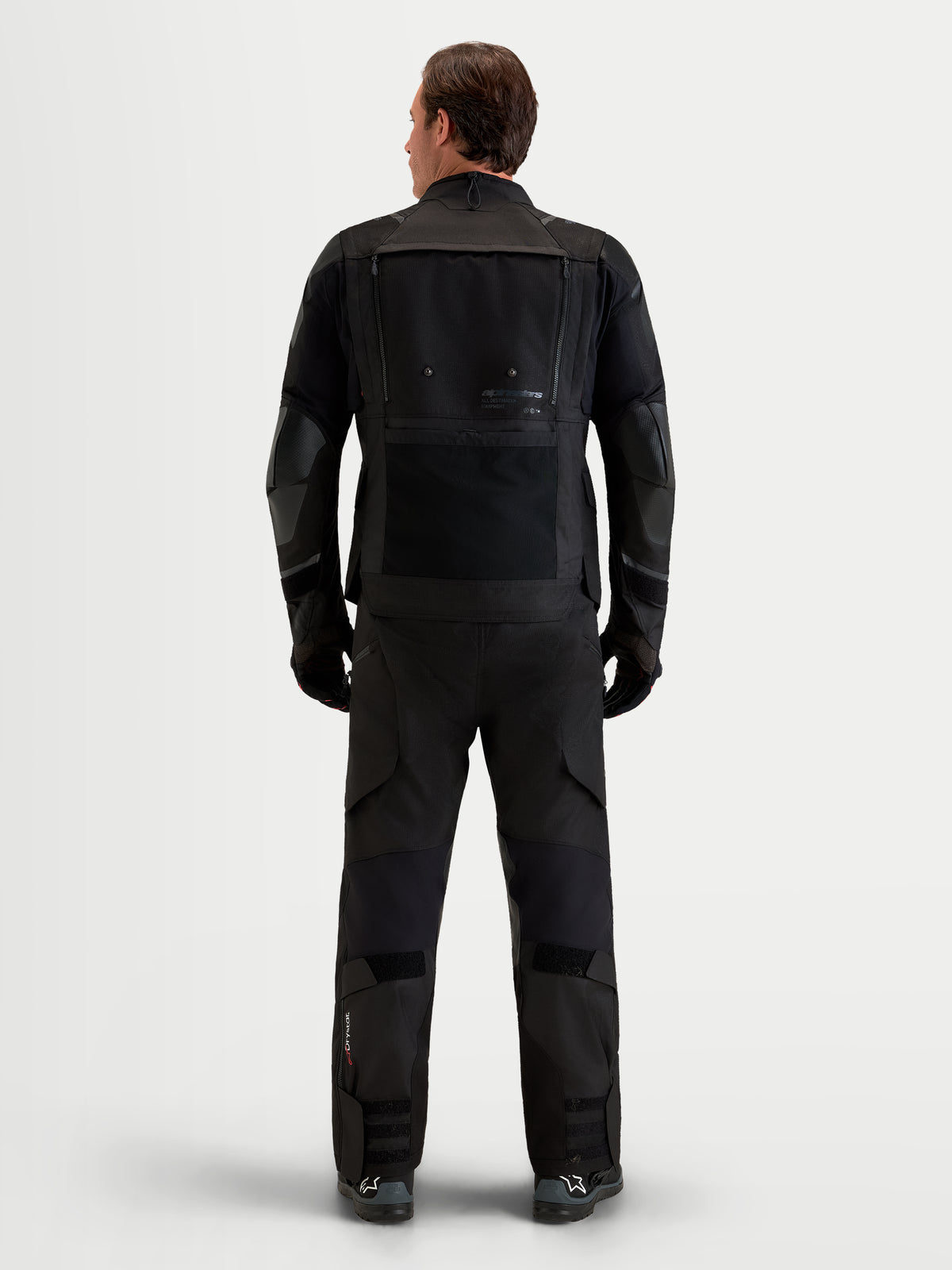 Alpinestars Harok V2 Drystar, męska czarna kurtka motocyklowa all-terrain adventure, widok z tyłu pokazujący modułowy panel wentylacyjny na plecach i konstrukcję z ripstopu