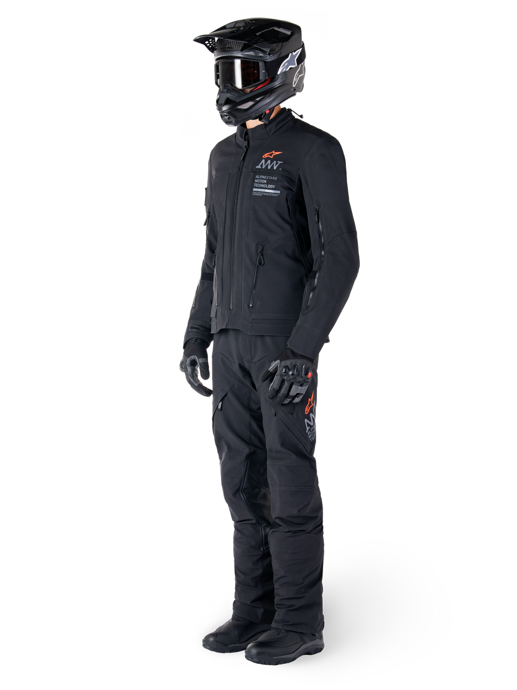 Kurtka Alpinestars AMT-8 Stretch Drystar® XF, motocyklowa kurtka adventure, czarna, noszona z pasującymi spodniami, kaskiem i rękawicami, z oznaczeniami Alpinestars Motion Technology i pomarańczowymi akcentami, wytrzymała elastyczna konstrukcja do jazdy przygodowej