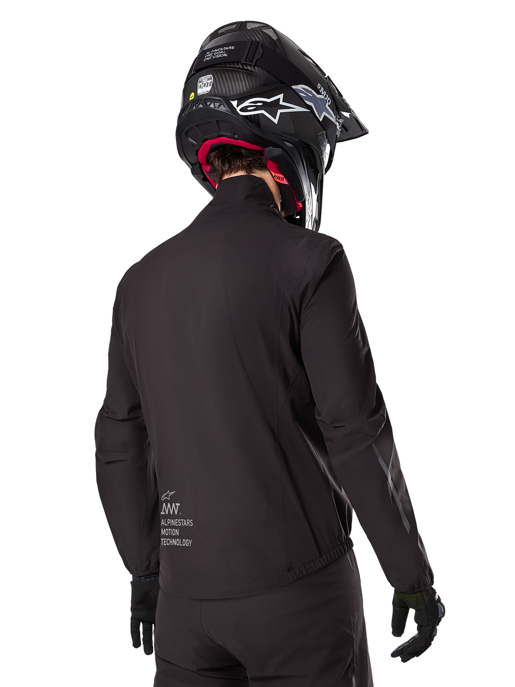 Alpinestars AMT-8 Stretch Drystar® XF Liner, czarna wodoodporna podszewka kurtki, widok z tyłu na motocyklistę w czarnym kasku i rękawicach, z logo Alpinestars Motion Technology na dole pleców, minimalistyczny i funkcjonalny design do jazdy adventure