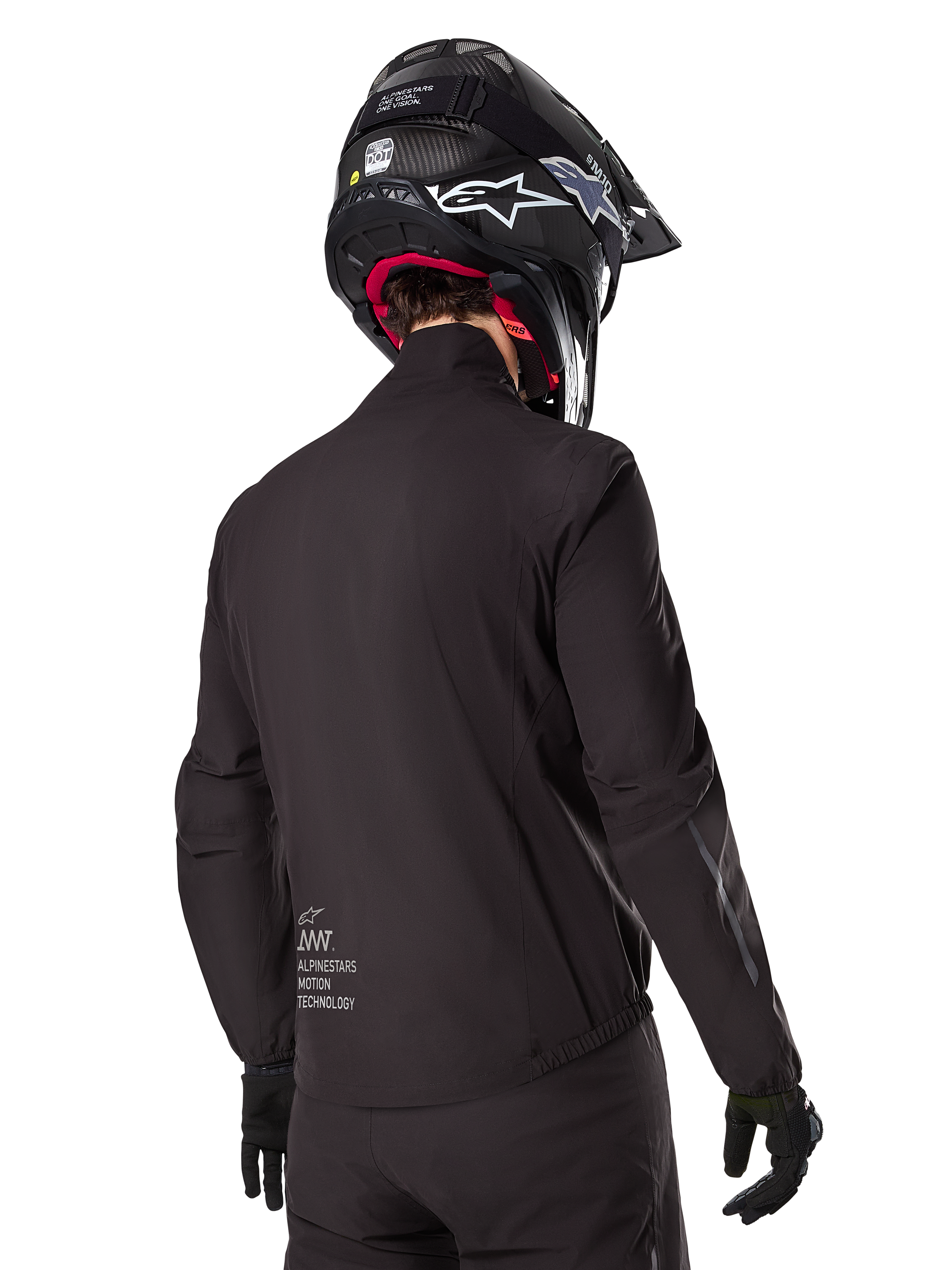 Alpinestars AMT-8 Stretch Drystar® XF Liner, czarna wodoodporna podszewka kurtki, widok z tyłu na motocyklistę w czarnym kasku i rękawicach, z logo Alpinestars Motion Technology na dole pleców, minimalistyczny i funkcjonalny design do jazdy adventure