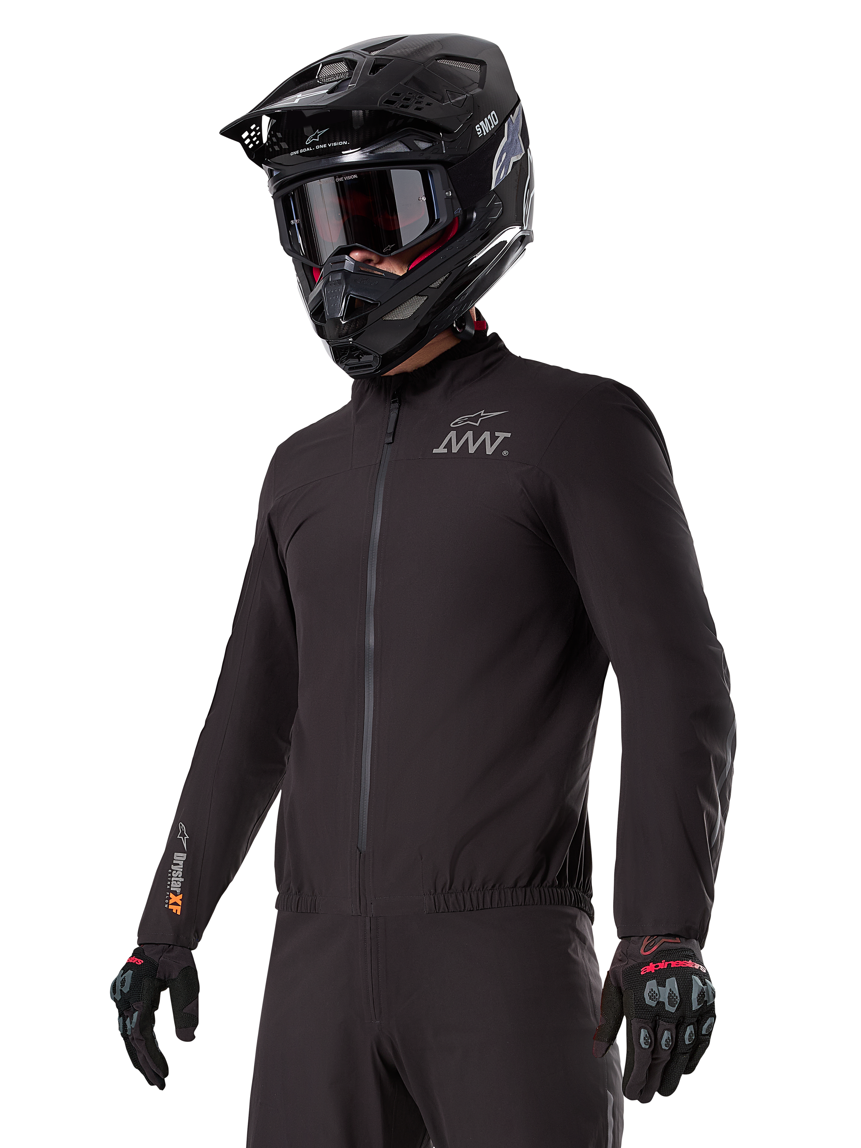 Motocyklista w podpince Alpinestars AMT-8 Stretch Drystar® XF Liner, czarna wiatroszczelna i wodoodporna elastyczna kurtka, z logo AMT na klatce piersiowej i oznaczeniem Drystar XF na rękawie, w zestawie z czarnym kaskiem adventure i rękawicami ochronnymi.