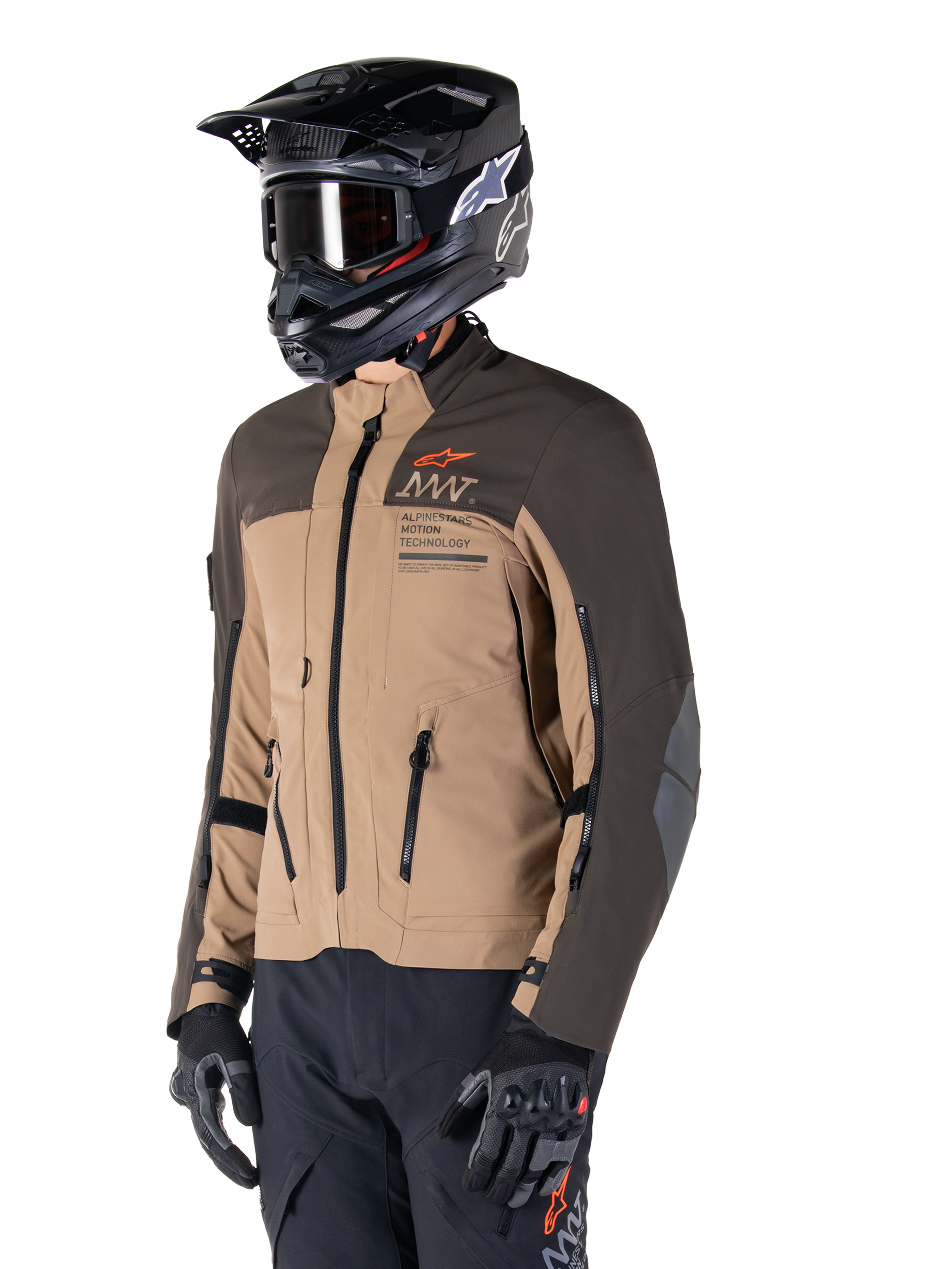 Kurtka Alpinestars AMT-8 Stretch Drystar® XF, motocyklowa kurtka adventure, ciemnobrązowa i ciemne khaki, noszona z czarnym kaskiem off-road i goglami, z logo Alpinestars Motion Technology i zamkami wentylacyjnymi