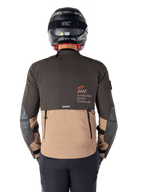 Kurtka Alpinestars AMT-8 Stretch Drystar® XF, widok z tyłu, dwukolorowa konstrukcja w odcieniach ciemnego brązu i ciemnego khaki, logo Alpinestars Motion Technology, tylna kieszeń cargo na zamek, ochronne panele na łokciach, odzież motocyklowa adventure touring