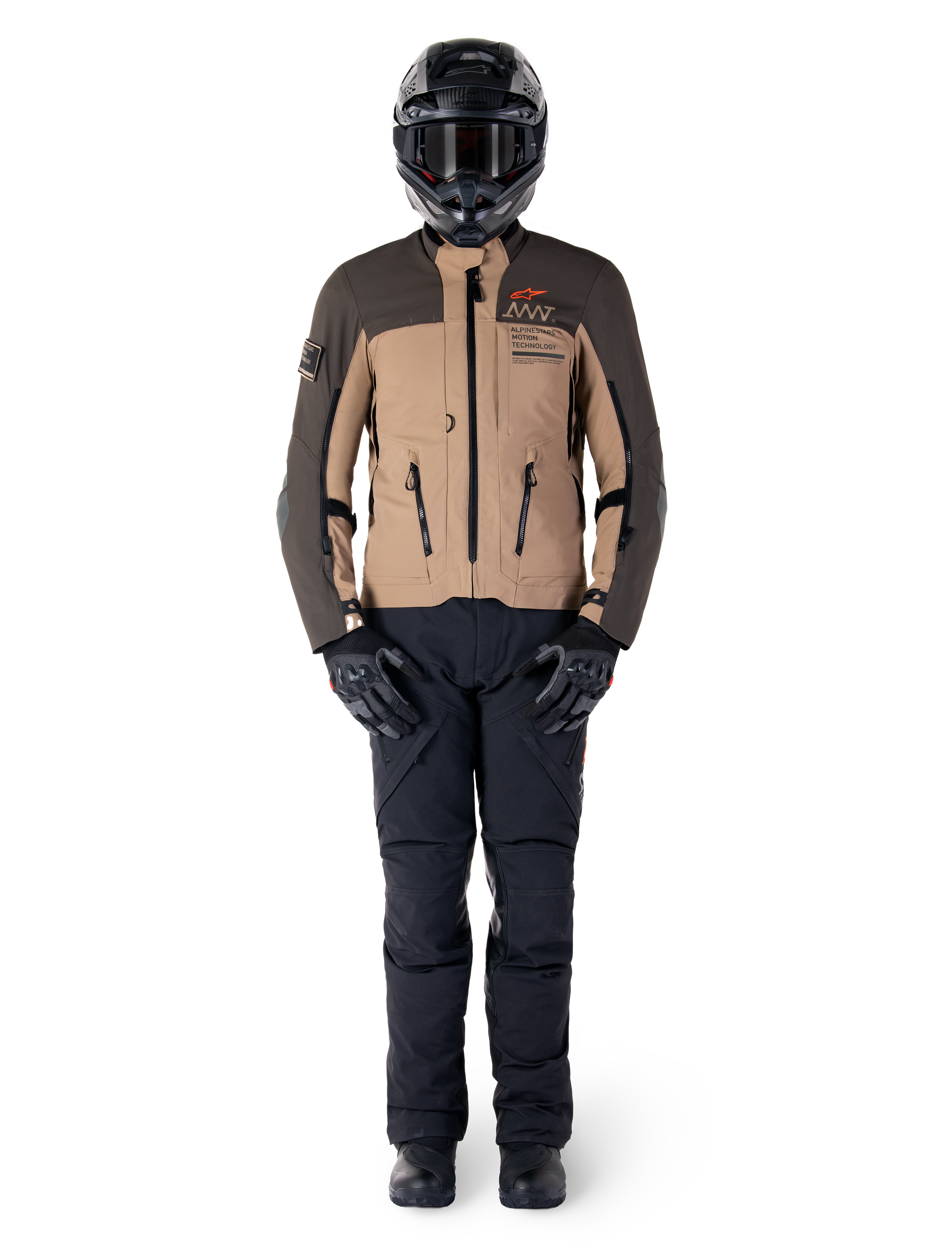 Kurtka Alpinestars AMT-8 Stretch Drystar® XF, kurtka motocyklowa adventure, ciemnobrązowa i ciemne khaki, noszona z czarnym kaskiem, goglami, czarnymi rękawicami, spodniami i butami, posiada otwory wentylacyjne na klatce piersiowej i branding AMT, dopasowany zestaw odzieży do turystyki przygodowej