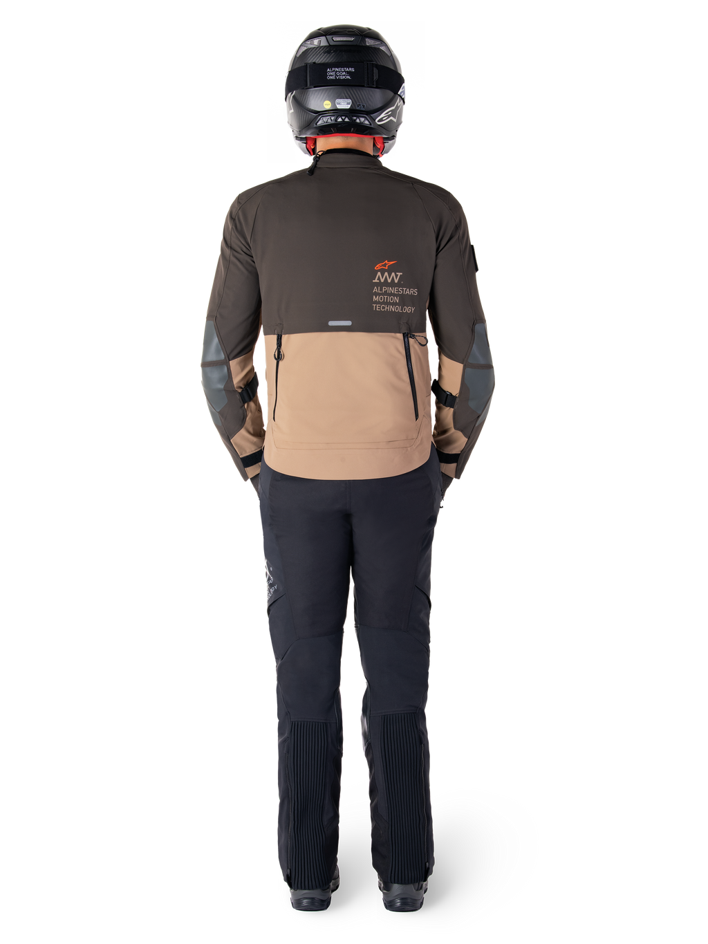 Kurtka Alpinestars AMT-8 Stretch Drystar® XF, kurtka turystyczna adventure, ciemnobrązowa i ciemne khaki, widok z tyłu prezentujący branding Alpinestars Motion Technology na plecach, noszona z czarnymi spodniami i czarnym kaskiem integralnym, techniczny elastyczny materiał dla odzieży motocyklowej adventure