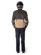 Kurtka Alpinestars AMT-8 Stretch Drystar® XF, kurtka turystyczna adventure, ciemnobrązowa i ciemne khaki, widok z tyłu prezentujący branding Alpinestars Motion Technology na plecach, noszona z czarnymi spodniami i czarnym kaskiem integralnym, techniczny elastyczny materiał dla odzieży motocyklowej adventure