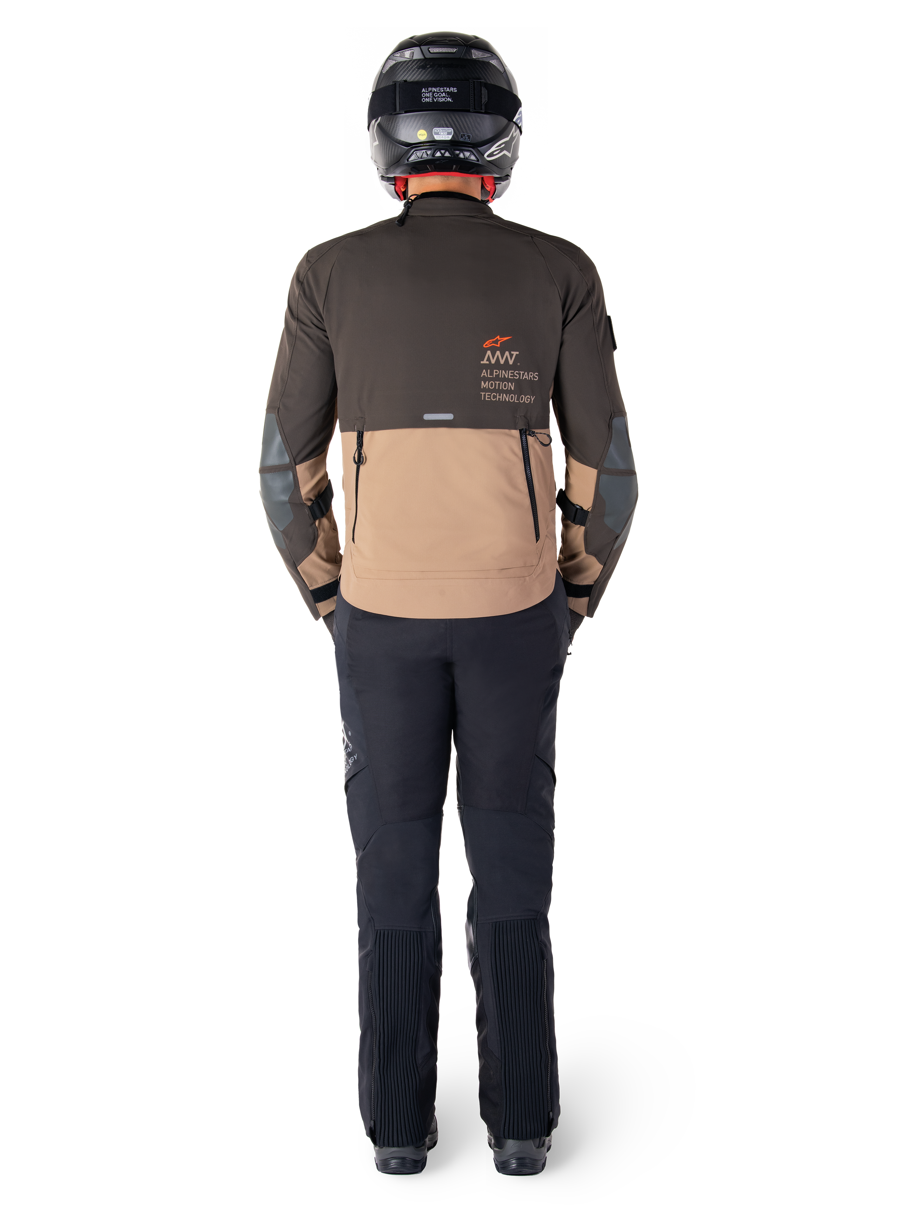 Kurtka Alpinestars AMT-8 Stretch Drystar® XF, kurtka turystyczna adventure, ciemnobrązowa i ciemne khaki, widok z tyłu prezentujący branding Alpinestars Motion Technology na plecach, noszona z czarnymi spodniami i czarnym kaskiem integralnym, techniczny elastyczny materiał dla odzieży motocyklowej adventure