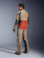 Kurtka Alpinestars AMT-8 Stretch Drystar® XF, motocyklowa kurtka adventure, kolor Walnut Rust i czarny, widok z tyłu na modelu w dopasowanych spodniach i butach adventure, wysoce oddychająca odzież tekstylna do turystyki motocyklowej