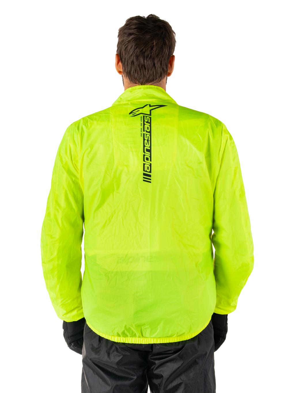 Alpinestars Hurricane Rain V2 Jacket, motocyklowa kurtka przeciwdeszczowa, żółty neonowy, widok z tyłu pokazujący pionowe czarne logo Alpinestars na środku pleców, lekka wodoodporna tkanina, zestawiona z czarnymi spodniami i rękawicami